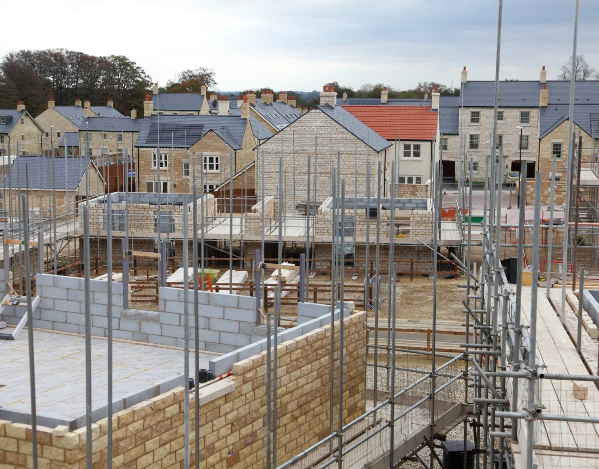 Housing development under construction with scaffolding, representing IT support for construction and property