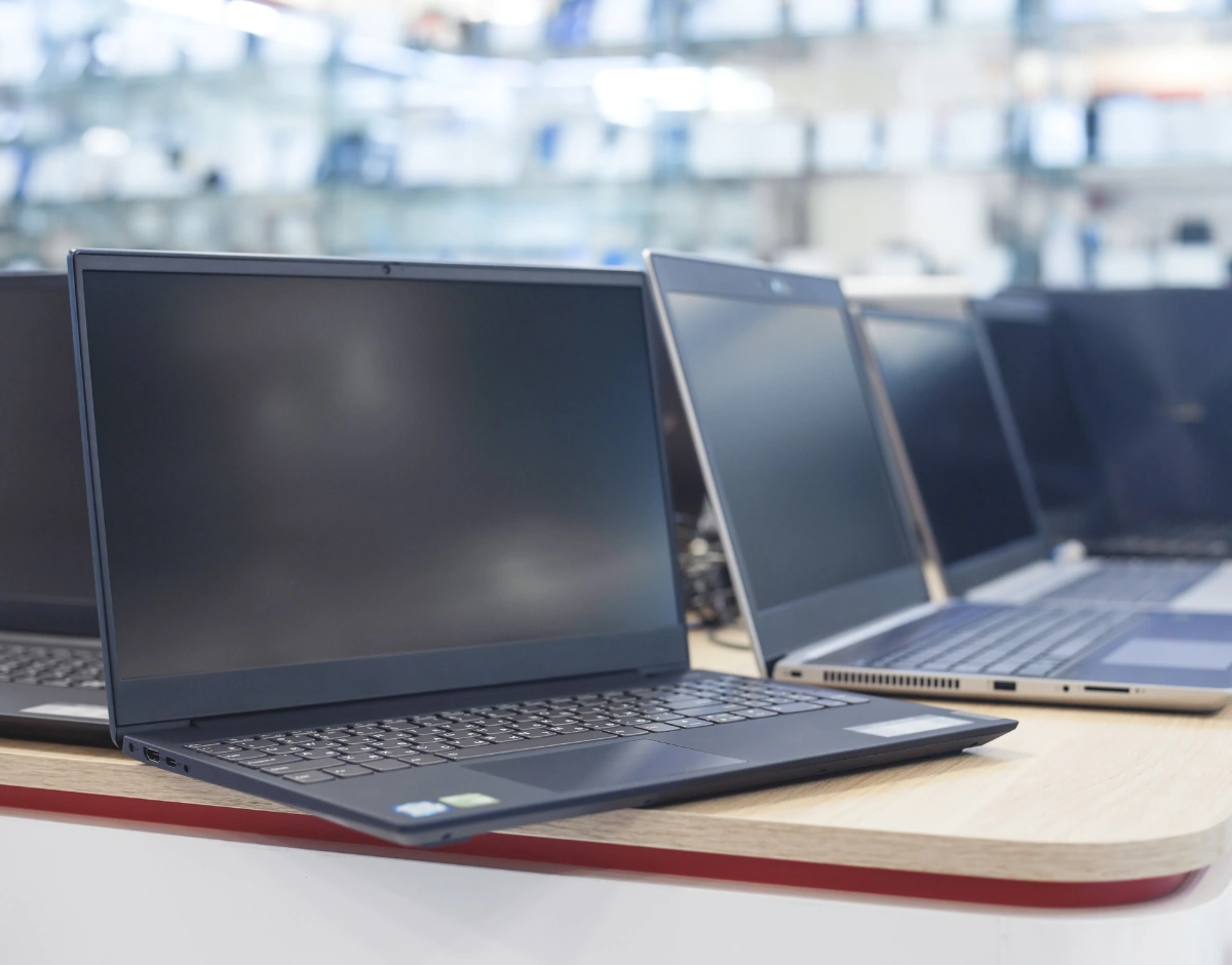 Row of business laptops on display, representing hardware and device supply