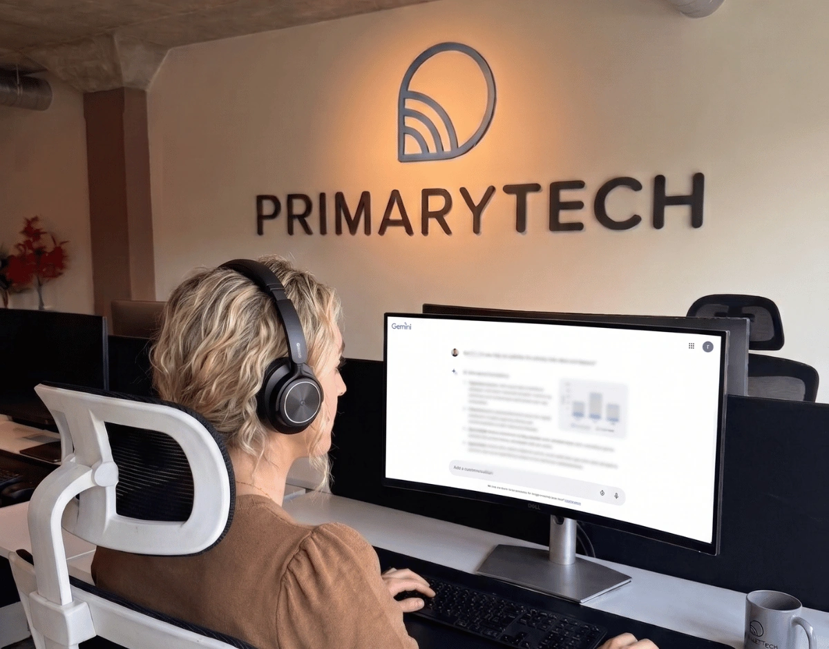 PrimaryTech team member using Google Gemini AI on their monitor at a desk in the Hull office