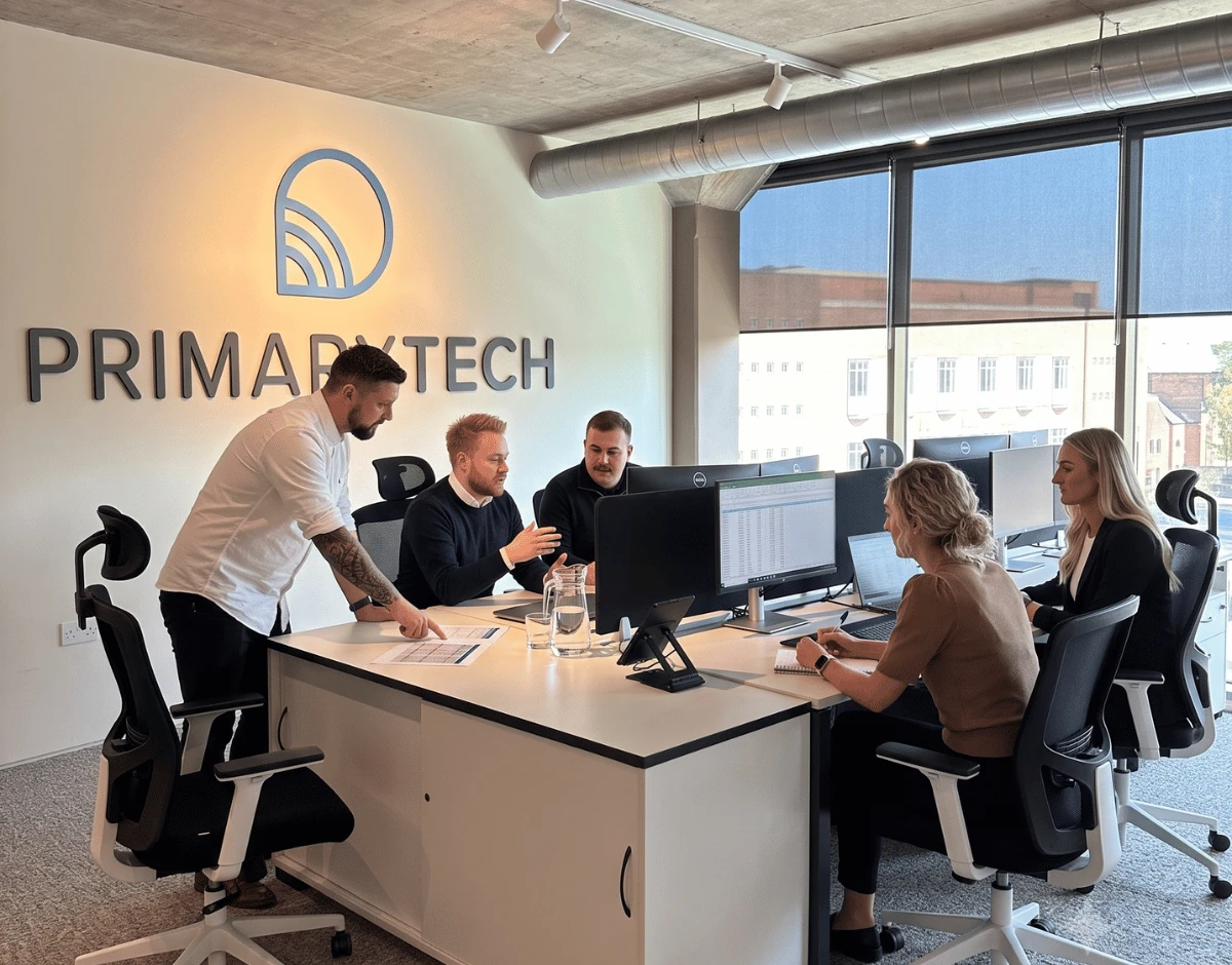 PrimaryTech team collaborating around a desk in the Hull office